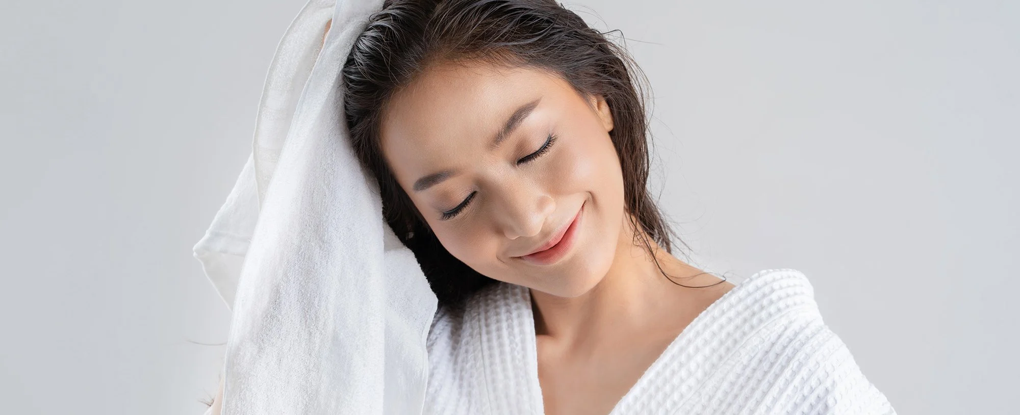 smiling woman with wet hair wrapped in a white towel
