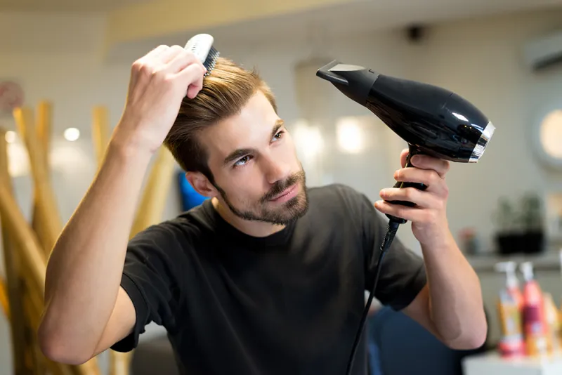 a man who uses a hair dryer