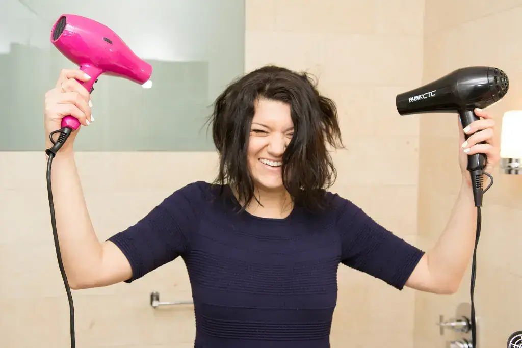Woman hold hair dryers 6 inches away from hair 