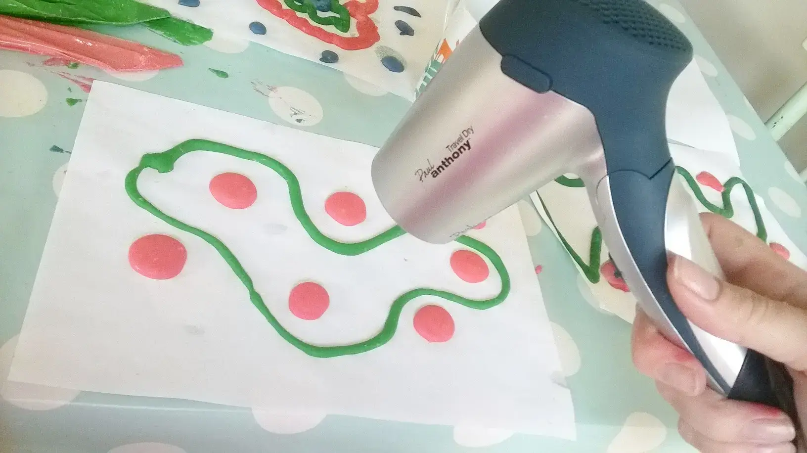 Using a hairdryer to speed dry puffy paint on paper.
