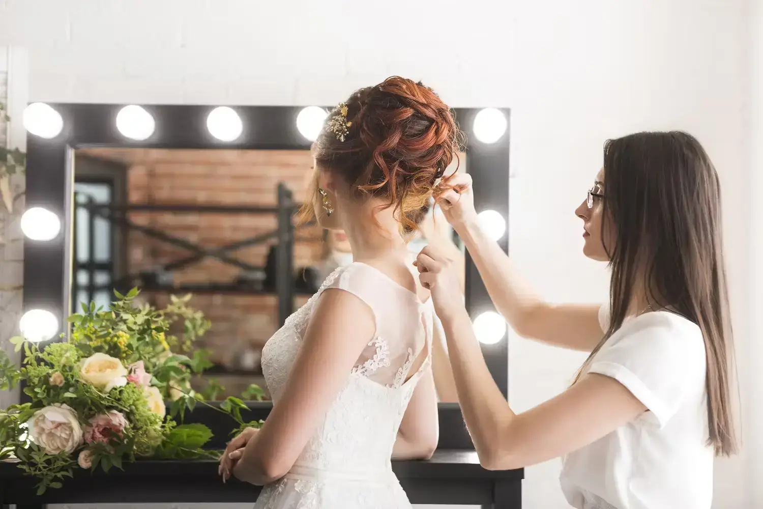Stylist creating an updo for a bride in a salon.