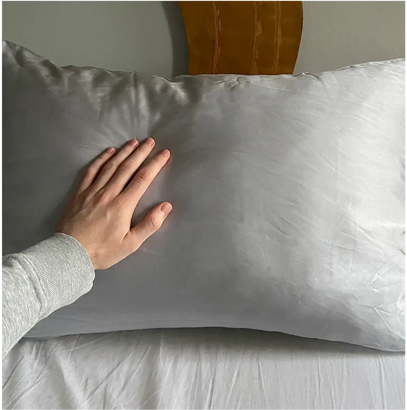 Hand pressing on a pillow, testing its softness.