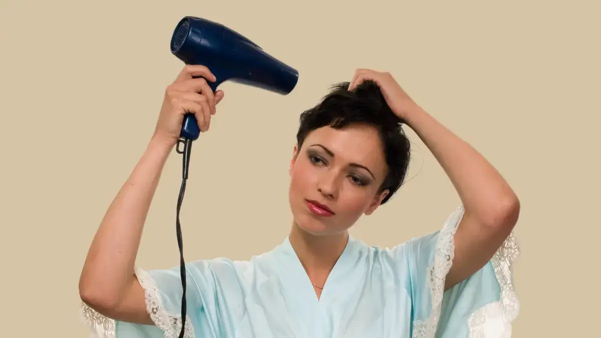 an unhappy woman drying her hair with a hair dryer for a long time