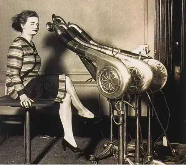 Vintage hair drying machine in use by a woman.