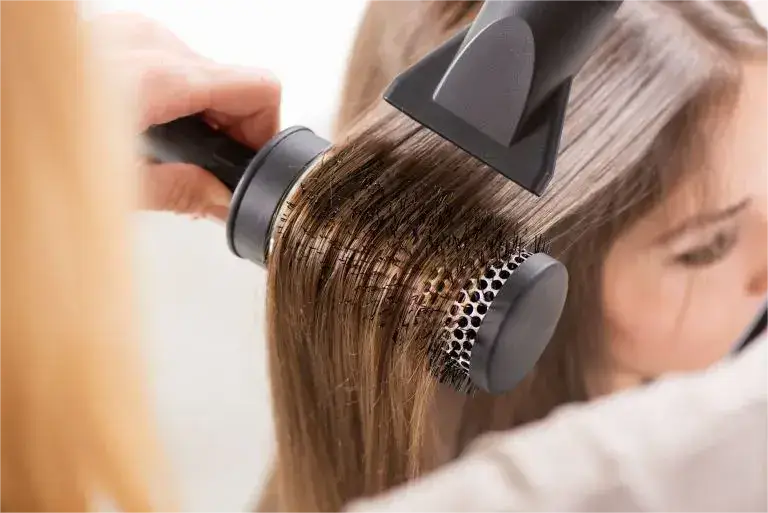 Hairbrush attachment being used on long, straight hair.
