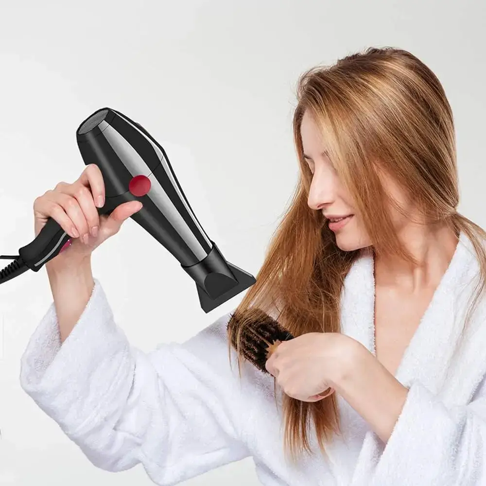 A woman dries her hair with an ergonomic hair dryer