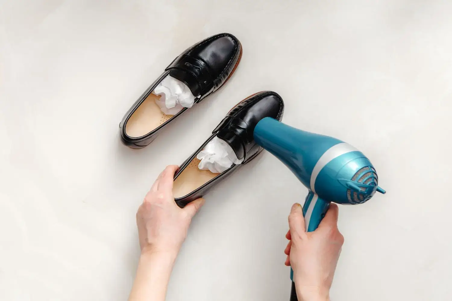 Stretching out shoes with a hairdryer and paper stuffing.