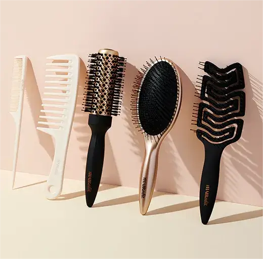 Assortment of hair brushes and combs on a pink background.