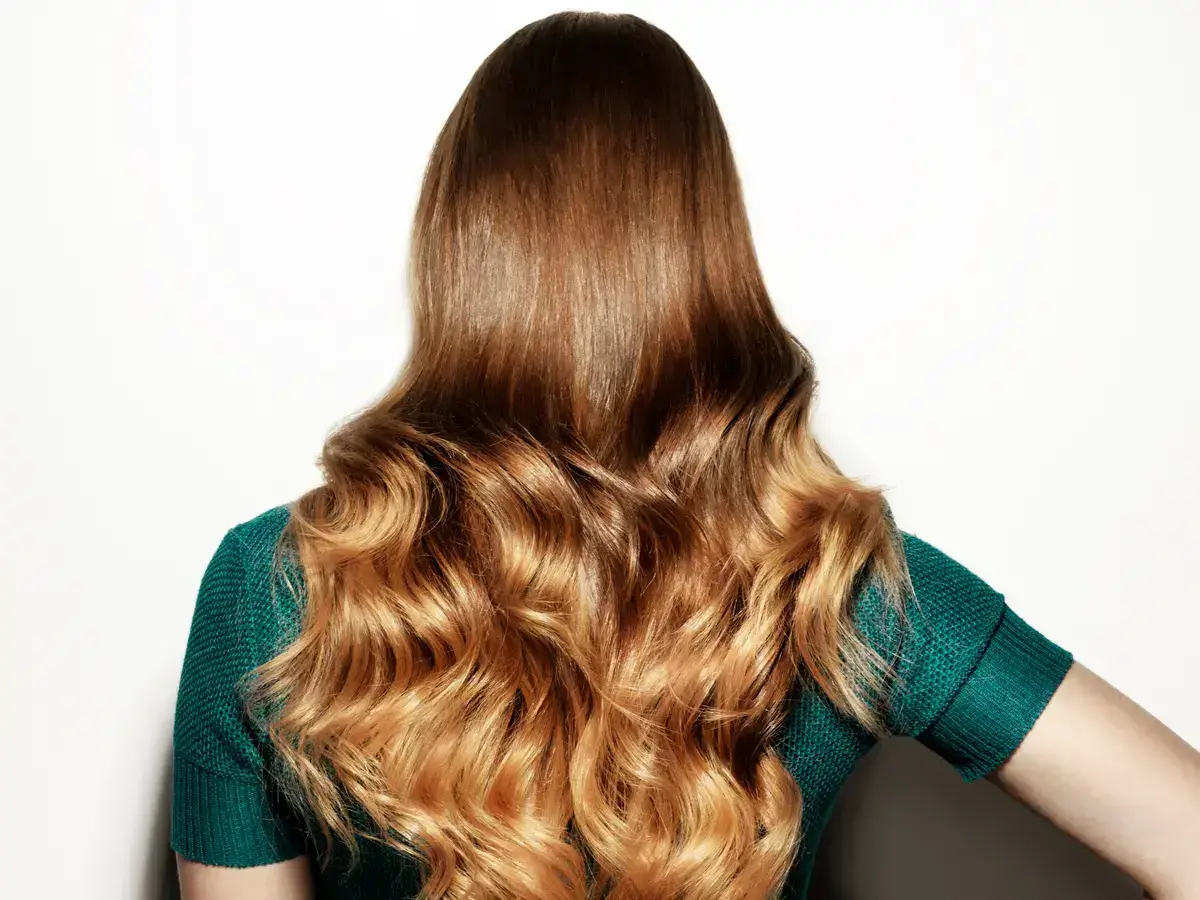 Woman's hair with soft curls, healthy shine.