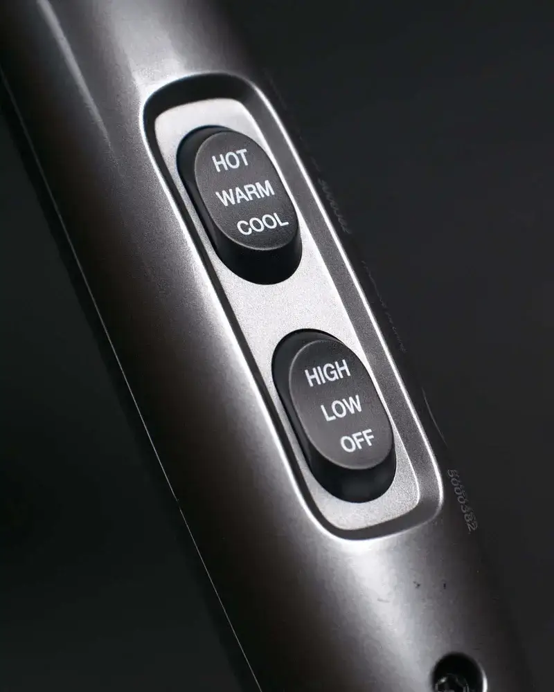 Close-up of hair dryer settings: temperature and speed controls.