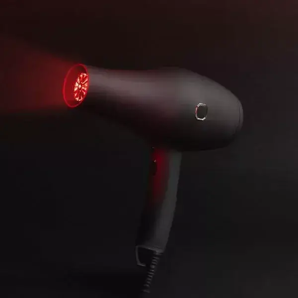 Sleek hair dryer emitting infrared light for drying hair.