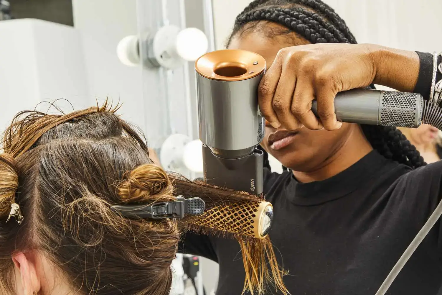 Stylist using a modern hair dryer on a client.