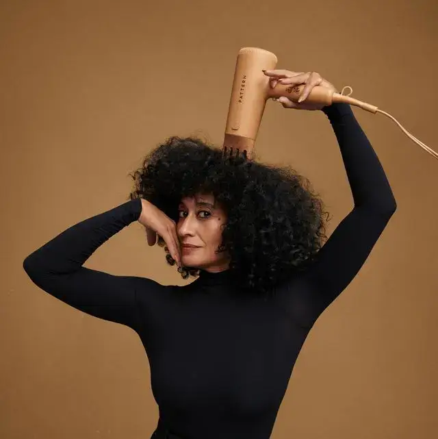Stylish person creatively drying curly hair with a hairdryer.