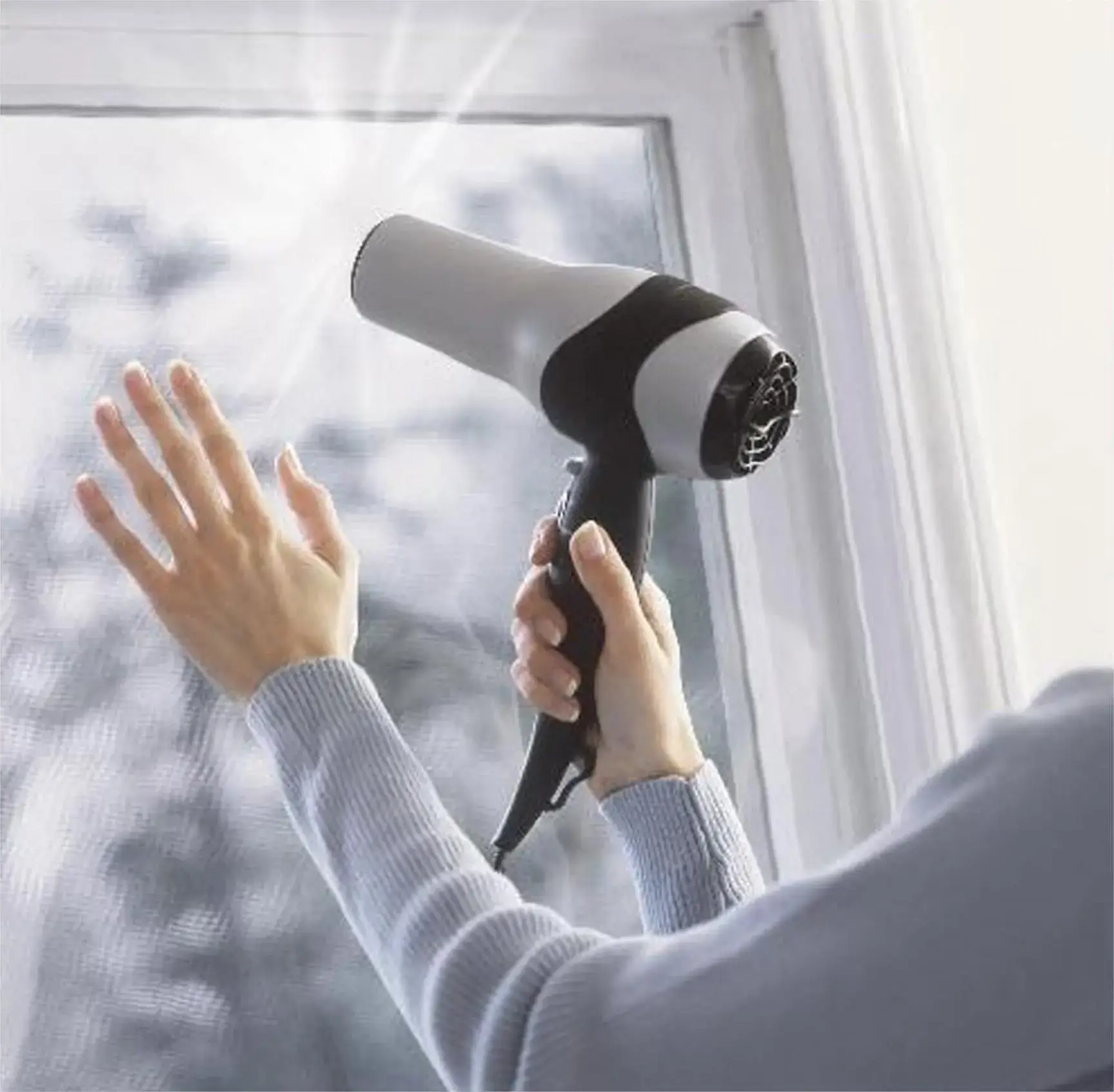 Removing moisture from a window pane using a hairdryer.