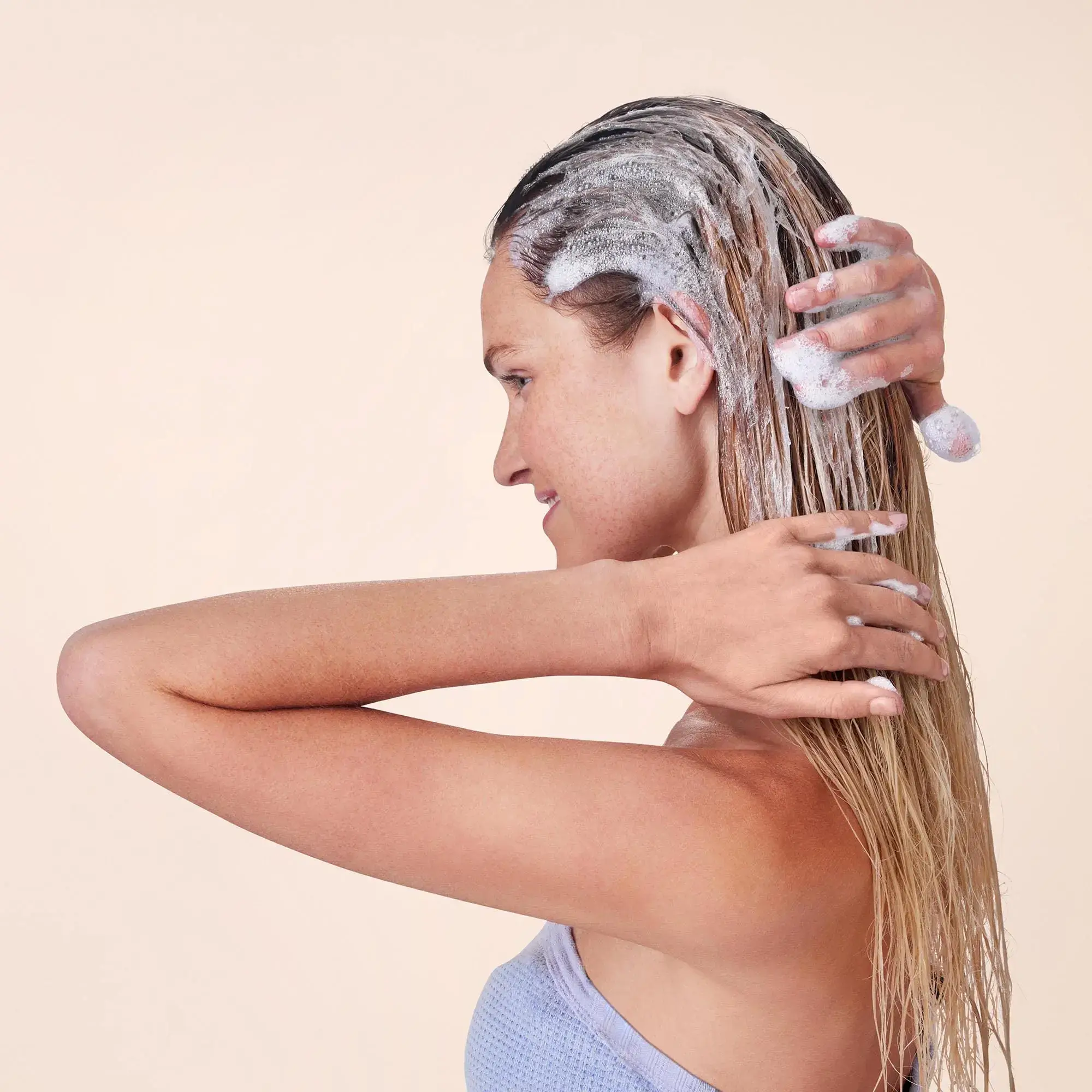 Woman applying shampoo to her hair.