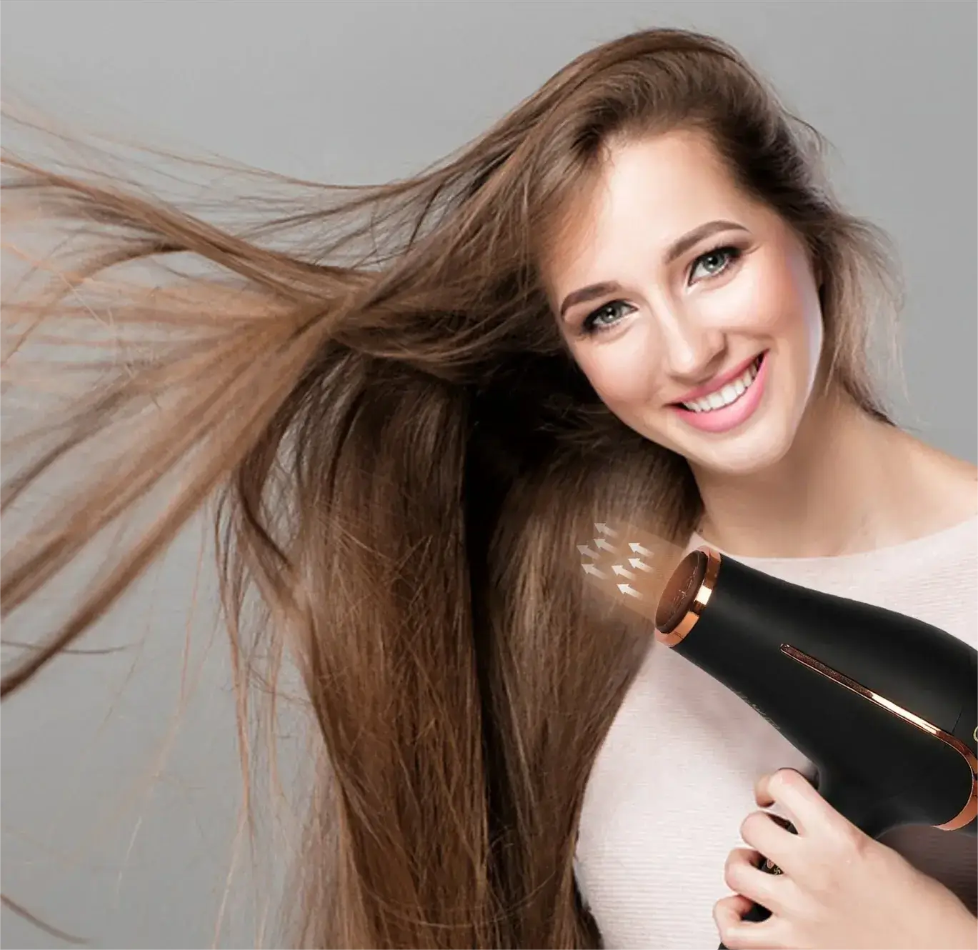 Smiling woman using hairdryer on long, flowing brown hair.