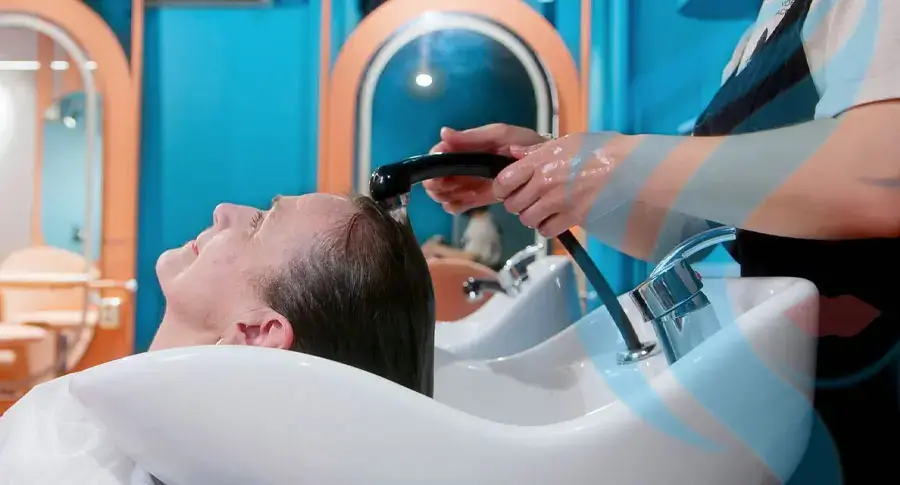 Woman relaxing during a hair washing session at a salon.