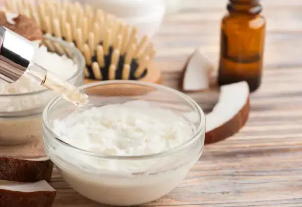 Coconut hair mask with natural ingredients and brush.