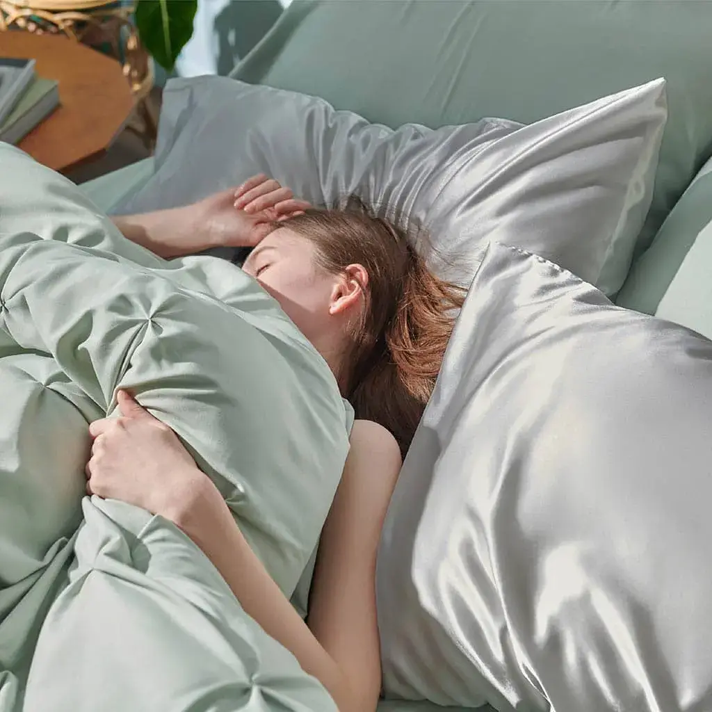 Person sleeping on a satin pillowcase to protect hair.