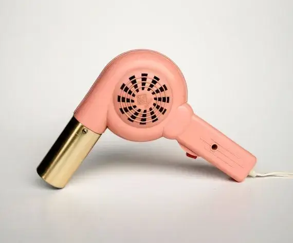 Vintage pink and gold hair dryer, classic design.