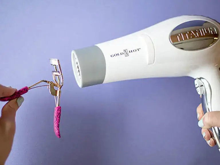 Warming eyelash curler with a blow dryer for better curl.